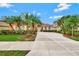 Mediterranean style home with palm trees and manicured lawn at 1151 Creek Nine Dr, North Port, FL 34291