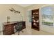 Home office with wood desk, built-in shelving, and window views at 1151 Creek Nine Dr, North Port, FL 34291