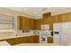 Modern kitchen with wood cabinetry, white appliances, and an eat-in breakfast bar at 1151 Creek Nine Dr, North Port, FL 34291