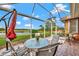 This screened patio offers a serene view and outdoor dining at 1151 Creek Nine Dr, North Port, FL 34291