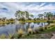 Stunning aerial view of the community showcasing a peaceful lake and mature trees at 1174 Bird Bay Way # 107, Venice, FL 34285