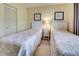 Guest bedroom with two twin beds, updated decor, and ample closet space at 1174 Bird Bay Way # 107, Venice, FL 34285