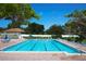 Inviting community pool with lounge chairs and umbrellas at 1174 Bird Bay Way # 107, Venice, FL 34285