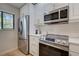 Modern kitchen features stainless steel appliances and white cabinetry at 1174 Bird Bay Way # 107, Venice, FL 34285
