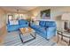 Living room with two blue sofas and wood flooring at 1174 Bird Bay Way # 107, Venice, FL 34285