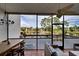 Spacious screened patio with lake and fountain views, dining table and seating area at 1174 Bird Bay Way # 107, Venice, FL 34285