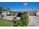Ranch-style home with stone accents, mature landscaping, and a flag at 126 Venice East Blvd, Venice, FL 34293