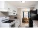Modern kitchen with white cabinets, black appliances and tile backsplash at 126 Venice East Blvd, Venice, FL 34293