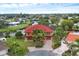 Aerial view of a two-story house with red tile roof, situated on a canal at 135 Tina Island Dr, Osprey, FL 34229