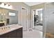 Elegant bathroom with a marble-tiled shower, a sleek vanity, and a walk-in closet at 169 N Cayman Isles Blvd, Englewood, FL 34223