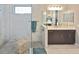 Bright bathroom with a marble-tiled shower, glass enclosure and updated fixtures at 169 N Cayman Isles Blvd, Englewood, FL 34223