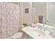 Well-lit bathroom featuring a floral shower curtain, a toilet, and a vessel sink at 169 N Cayman Isles Blvd, Englewood, FL 34223
