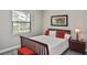 Bedroom with a dark wood bed frame, a window with blinds, and a nightstand at 169 N Cayman Isles Blvd, Englewood, FL 34223