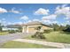 Well-maintained home featuring a paver driveway, manicured lawn, and a three-car garage under a cloudy sky at 169 N Cayman Isles Blvd, Englewood, FL 34223