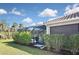 Exterior view shows screened-in pool with tropical landscaping, complemented by lush bushes and a clay tile roof at 169 N Cayman Isles Blvd, Englewood, FL 34223