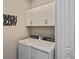 Bright laundry room featuring white cabinetry, washer, and dryer at 169 N Cayman Isles Blvd, Englewood, FL 34223