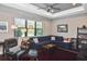Cozy living room featuring a comfortable blue sectional sofa, plush rug, and large windows for natural light at 169 N Cayman Isles Blvd, Englewood, FL 34223