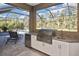 Outdoor kitchen with stainless steel grill and granite countertops at 169 N Cayman Isles Blvd, Englewood, FL 34223