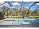 Screened pool and spa with brick and tile deck offer a private backyard oasis with tropical landscaping at 169 N Cayman Isles Blvd, Englewood, FL 34223