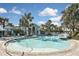 Expansive community pool featuring a zero entry, abundant seating, and a charming pool house surrounded by palms at 169 N Cayman Isles Blvd, Englewood, FL 34223