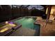 Nighttime view of a screened-in pool and spa illuminated by colorful lights and landscape lighting at 169 N Cayman Isles Blvd, Englewood, FL 34223