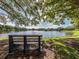 Serene lake view with bench under shade trees at 406 Pendleton Dr, Venice, FL 34292