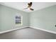 Bright bedroom with green walls, ceiling fan, and window overlooking backyard at 4467 Cinderella Cir, North Port, FL 34286
