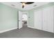 Bedroom with green walls, ceiling fan, and view into living area at 4467 Cinderella Cir, North Port, FL 34286