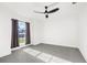Bright bedroom with grey tile floors, ceiling fan, and window with grey curtains at 4467 Cinderella Cir, North Port, FL 34286