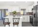 Modern kitchen with white cabinets, island, and stainless steel appliances at 4467 Cinderella Cir, North Port, FL 34286