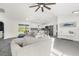 Open living space with gray sectional sofa, kitchen, and access to backyard at 4467 Cinderella Cir, North Port, FL 34286