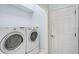 Bright laundry area featuring a side-by-side washer and dryer, conveniently located near a door at 5019 Bella Terra Dr, Venice, FL 34293