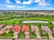 Community view showcasing houses with red tile roofs near a golf course and lake at 5633 Whispering Oaks Dr, North Port, FL 34287