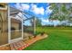 Landscaped backyard with screened patio and golf course view at 5633 Whispering Oaks Dr, North Port, FL 34287