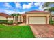 Single-story home with red tile roof, brick driveway, and landscaped yard at 5633 Whispering Oaks Dr, North Port, FL 34287