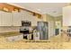 Modern kitchen featuring granite countertops, stainless steel appliances, and white cabinetry at 5633 Whispering Oaks Dr, North Port, FL 34287