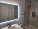 Modern bathroom with a backlit mirror, marble tile, and bathtub at 606 Marcus St # 26, Venice, FL 34285