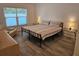 Spacious bedroom with a queen bed, bedside tables, lamps, and a sunny window at 606 Marcus St # 26, Venice, FL 34285