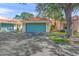 Villa with a two-car garage door painted light blue and a Spanish tile roof at 606 Marcus St # 26, Venice, FL 34285