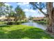 Community pond with fountain, lush landscaping, and villas visible at 606 Marcus St # 26, Venice, FL 34285