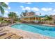 Community pool and covered patio with seating and lounge chairs on a sunny day at 606 Marcus St # 26, Venice, FL 34285