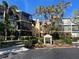 Inviting condo complex with lush landscaping and palm trees on a sunny day, creating a tropical atmosphere at 612 Bird Bay S Dr # 114, Venice, FL 34285