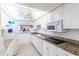 Well-equipped kitchen with granite countertops and white cabinets at 612 Bird Bay S Dr # 114, Venice, FL 34285