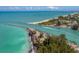 Aerial view of a boat entering a harbor with turquoise water and beaches at 669 Alligator Dr, Venice, FL 34293