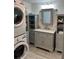 Modern bathroom with gray vanity and stacked washer/dryer at 782 Londra Dr, Venice, FL 34285