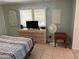 Bedroom with striped bedding, dresser, and small side table at 782 Londra Dr, Venice, FL 34285