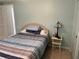 Bedroom with striped bedding and nightstand at 782 Londra Dr, Venice, FL 34285