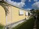 Side view of yellow mobile home with landscaping at 782 Londra Dr, Venice, FL 34285