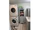 Laundry room with stackable washer and dryer, gray cabinet, and flooring at 782 Londra Dr, Venice, FL 34285
