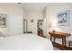 Bright bedroom with white walls, white bedding and a view into another room at 793 Vanderbilt Dr, Nokomis, FL 34275